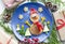 Christmas pancake shaped like snowman with fresh vegetables blue plate on wooden white table decorated festively
