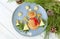 Christmas pancake shaped like snowman with fresh vegetablesn blue plate on wooden white table decorated festively