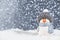 Christmas panorama background. Happy cute penguin in a winter hat on snowdrifts in the light of a lantern at night with hard