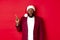 Christmas, party and holidays concept. Impressed Black man with beard, wearing santa hat, pointing finger left and