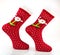 Christmas patterned  red knitted socks. Beautiful winter warm Christmas socks with a New Year`s pattern on a white background.