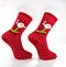 Christmas patterned  red knitted socks. Beautiful winter warm Christmas socks with a New Year`s pattern on a white background.