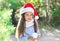 Christmas and people concept - portrait little child in santa hat with snowball