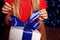 Christmas photo of little girl in red dress holding a white gift - box whith blue bow