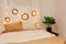 Christmas photo zone, bedroom. Bed with two pillows, home monstera plant. The walls are decorated with New Year\\\'s wreaths of