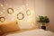 Christmas photo zone, bedroom. Bed with two pillows, home monstera plant. The walls are decorated with New Year\\\'s wreaths of