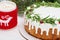 Christmas pie with rosemary and cranberries on white wooden table with and cup of cocoa.