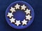 Christmas plate.  Blue ceramic plate, decorated with  home-baked cinnamon stars,  against a blu