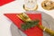 Christmas plate and goldware with red cloth with branch of fir tree