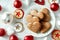 Christmas plate with homemade gingerbreads star baubles on a white table.