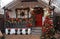Christmas porch decorated with glowing garlands, Christmas decorations, Christmas wreath on the door,flowers, Christmas trees with
