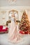 Christmas portrait of a girl in a glittering festive dress on the background of Christmas decor in elegant interior