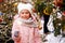 Christmas portrait of happy child girl holding burning sparkler or firework outdoor