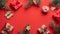 Christmas preparation concept. Flat lay, top view Christmas gifts, pine tree branches, ribbon, wooden decorations on red