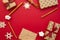Christmas presents. Gifts packed in craft paper, decorative snowflakes, twine, cinnamon sticks on red background. Xmas and Happy N
