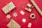Christmas presents preparation. Gifts packed in craft paper, decorative snowflakes, twine on red background. Xmas and Happy New Ye