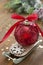 Christmas red bauble on sleigh with red ribbon bow, on wooden rustic table. Copy space