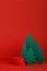 Christmas red cylinder podium mockup for presentation cosmetic products, gifts, goods with green paper spruce in minimal