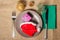 Christmas red hat and present in gift box on plate, fork and knife on green napkin, cone, glittering ball and natural fir tree br