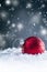 Christmas red Luxury ball in snow and abstract snowy atmosphere