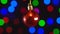 Christmas red mirror ball toy is spinning close-up. Decor with new year tree lights twinkling.