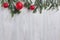 Christmas red toys, branches of spruce on a wooden background.