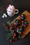 Christmas red white mug with hot drink and marshmallows and chocolate cupcakes with multicolored sweets and spruce sprig with pine