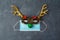 Christmas reindeer with medical face mask and party eyeglasses. Coronavirus protection minimal concept