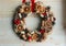 Christmas in a rustic style. Handmade decor. Christmas wreath on the background of old boards. Festive mood.