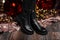 Christmas sale footwear. Winter collection of women`s warm leather shoes. Closeup of female legs in black trendy boots near