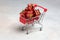 Christmas Sale. Gifts in the buyer`s basket. Full shopping cart. Grey background. The concept of purchases before the New Year