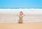 Christmas sandy snowman in santa hat at tropical beach