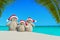 Christmas sandy Snowmen family in Santa hats at palm beach.