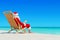 Christmas Santa Claus with fresh juice on sunlounger at tropical