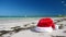 Christmas Santa Claus hat on tropical sandy beach with calm waves