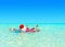 Christmas Santa Claus relax swimming in ocean turquoise transparent water.