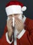 Christmas santa claus sneezing into tissue