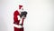 Christmas. Santa Claus on a white background wears black boxing gloves and fulfills punches. Kickboxing, fighter.