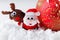 Christmas Santa and reindeer toys on snow with festive New Year balls