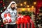 Christmas santa wishes merry christmas. Styling man with a long beard posing on the wooden background. Man new years eve