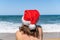 Christmas sea holiday. Woman in santa hat relaxing on paradise beach island getaway. New year.