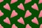 Christmas seamless pattern. Top view soft red heart pads on green background. Love concept flat lay