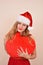 Christmas sensual girl with a big heart present, in Santa costume