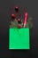 Christmas shopping green paper bag with bottle of champagne and holiday purchases on black background. Xmas concept