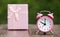 Christmas shopping, time to gift. Pink alarm clock and gift box