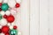 Christmas side border of red, green and white ornaments on white wood