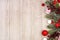 Christmas side border with red and white ornaments and branches, above view on a gray wood background