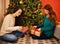 Christmas, smile and women with presents, tree with decor in living room for holiday. Gift giving, open and family