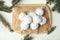 Christmas snowball cookies and fir tree branches on white table, flat lay