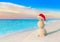 Christmas Snowman in red Santa hat at sunset sea beach